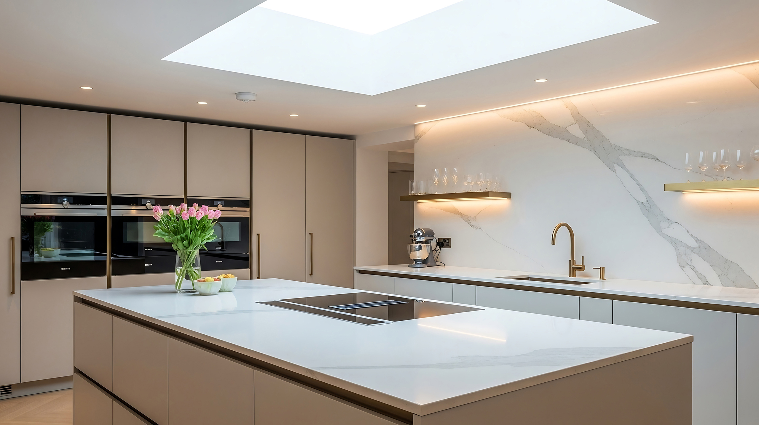 Sleek quartz stone kitchen island with brass fixtures and marble
