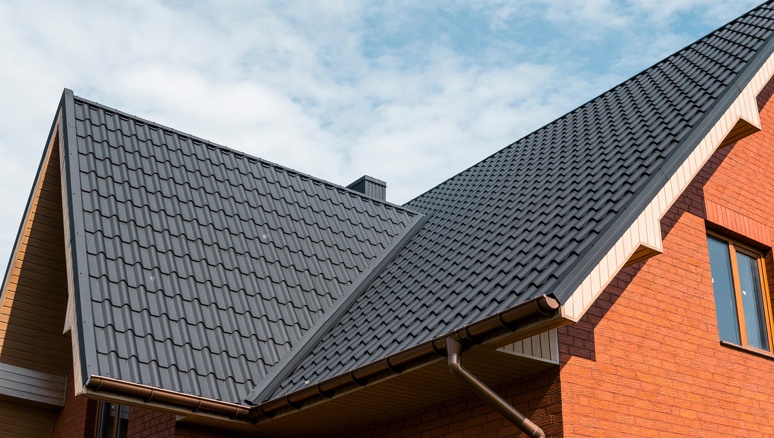 Modern roof covered with tile effect PVC coated brown metal roof sheets.